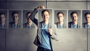 a man holding different photographs of his own face